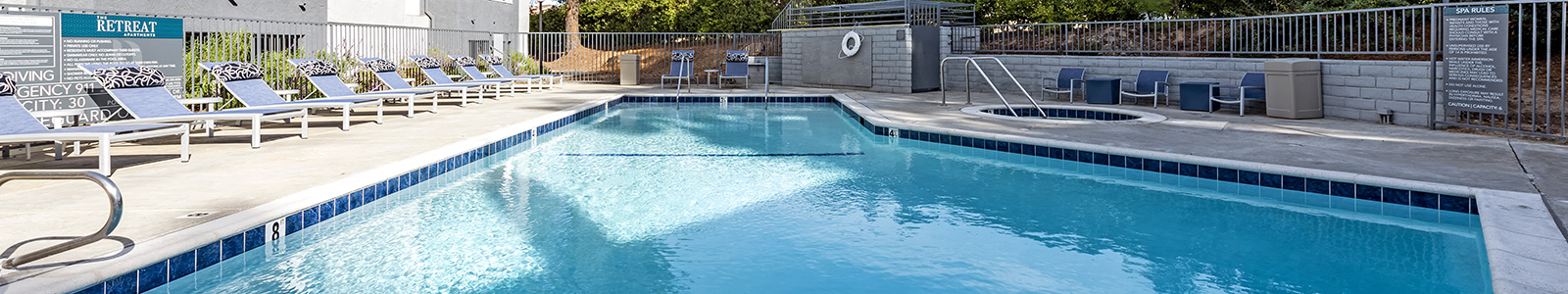 Pool with lounge chairs l The retreat apartments